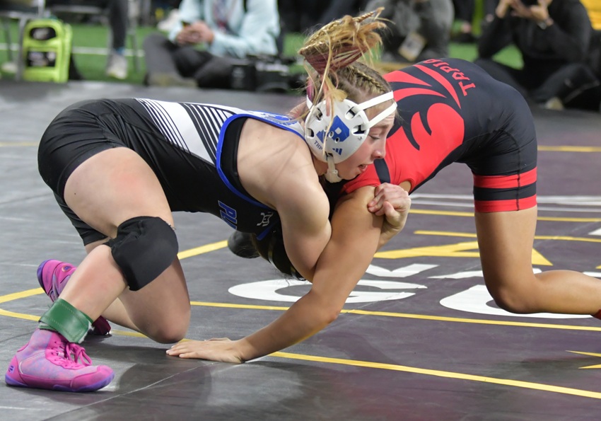 Plainwell's Madison Nieuwenhuis, left, puts a hold on Lowell's Veronica Tapia during their championship match.