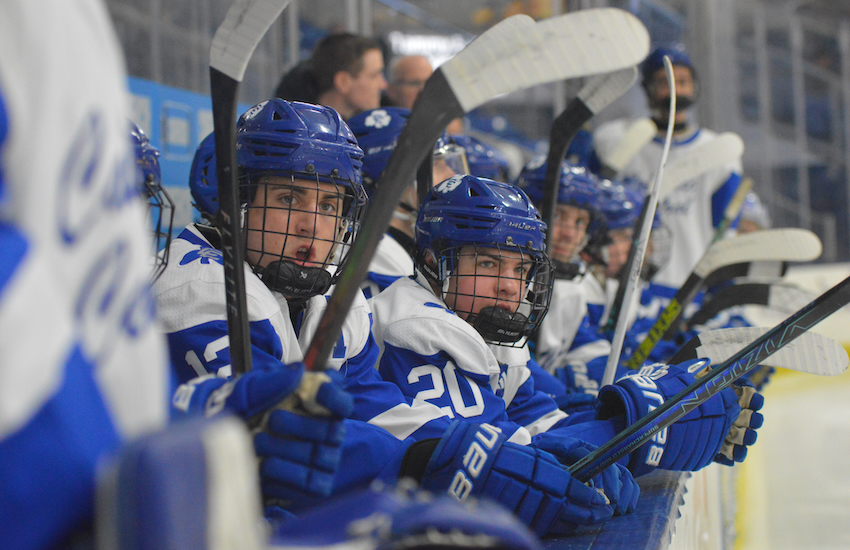 Detroit Catholic Central’s Matthew Naida (12) and Dominic Testani (20) monitor the action on the ice during their team’s 8-0 win over Rockford (21-9-1) on Friday.