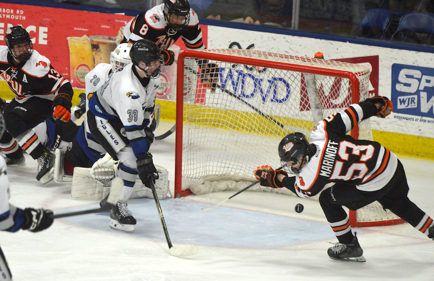 Northville's Tommy Marinoff sends a loose puck during Utica Eisenhower's net during his team's 3-2 double-overtime Division 1 Semifinal win Friday. Marinoff scored during the second period.
