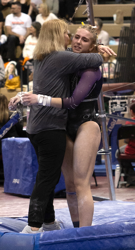 Haslett United’s Phoebe Elder, right, receives a hug after her bars routine. 