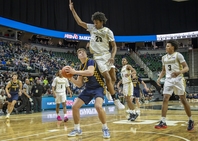 Elite’s Kaydin Banks (20) elevates to defend P-Ws Trent Piggott near the basket. 