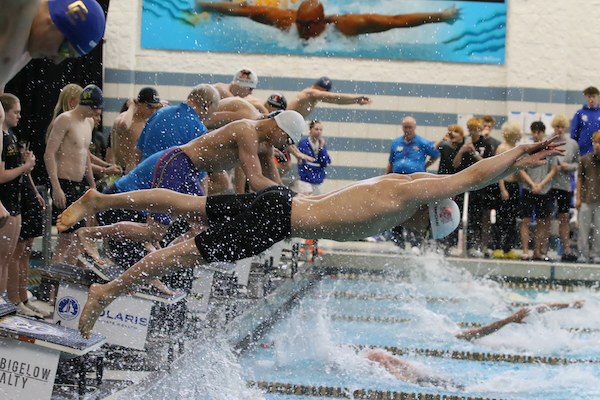 Swimmers launch during the start of the 200 freestyle relay. 