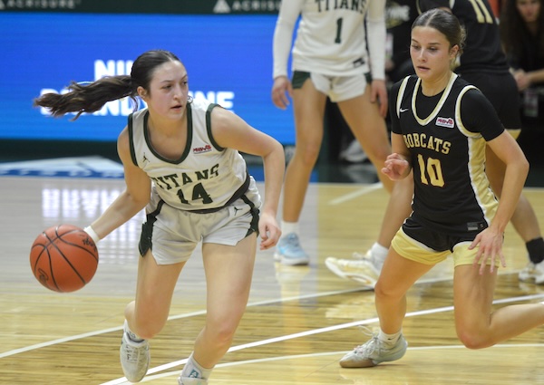 Lucy Wrozek (14) looks for an open teammate while Mackenna Price (10) pursues.
