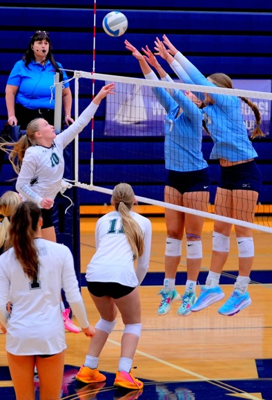 Maddie (left) and Laynie (right) are dominant forces at the volleyball net, shown here going up for a double block. 
