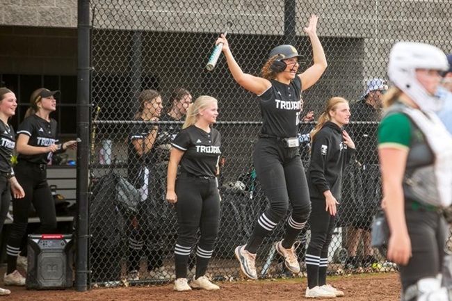 The Trojans’ dugout celebrates during a game.