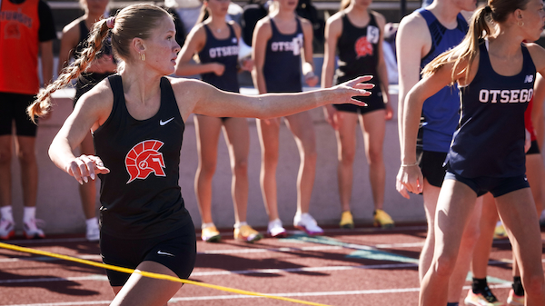 Senior Tessa Hatt prepares to take the baton from a teammate during the 3,200-meter relay this season against Otsego. 