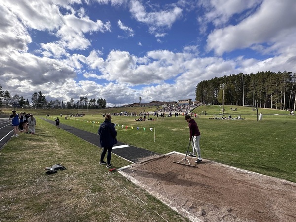 The long jump pit is prepared during the school’s first meet in nearly a decade. 