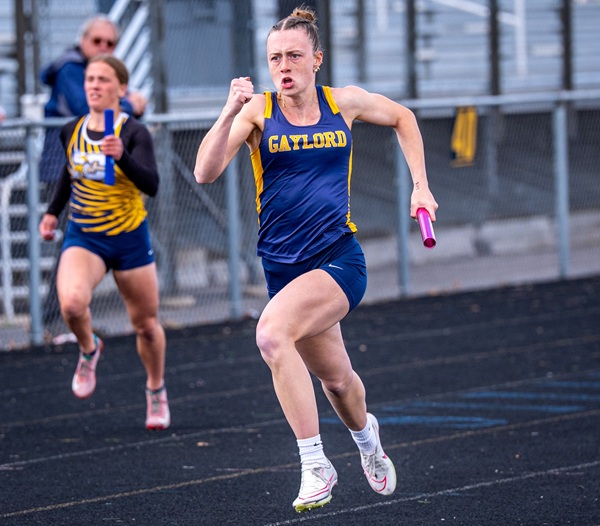 Mason carries the baton during a relay.