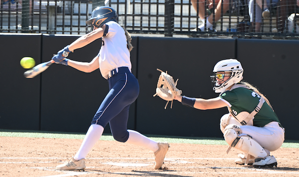 A Grand Haven hitter drives a pitch during her team’s Semifinal victory.