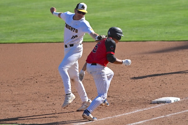 Kenowa Hills’ Bobby Haisma (19) applies a tag on Vicksburg’s Maddox Rosalin a few steps in front of first base.