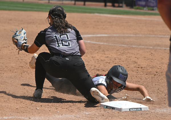 A Ravenna runner slides into third base while New Lothrop's Leigha Eagan awaits a throw.