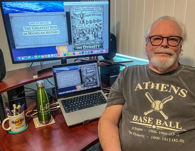 Videographer Larry DeBow sits at his work station with his latest work on Athens baseball displayed on his computer screen.