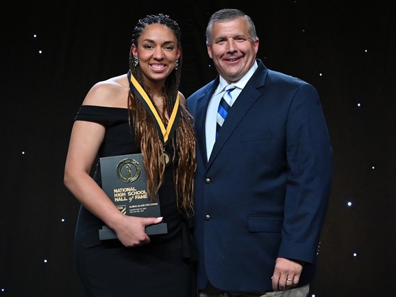 Alisha Glass Childress stands for a photo with MHSAA Executive Director Mark Uyl during her NFHS Hall of Fame induction June 29. 