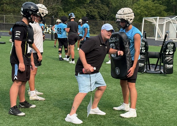 Eddie Ostipow works with the Huskies linemen.