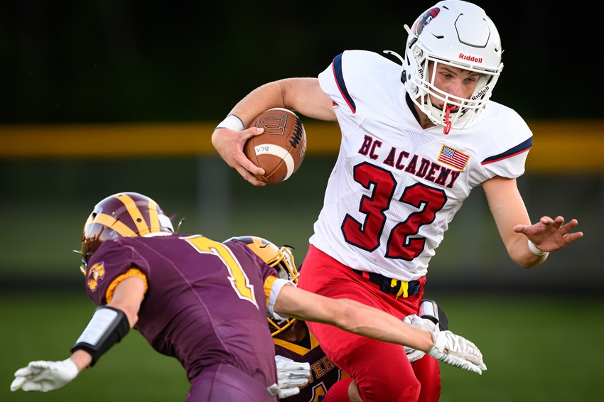 Bay City Academy senior running back Brody Trudell (32) takes on a pair of defenders during his team’s inaugural game on Thursday, a 20-18 loss to Au Gres-Sims.