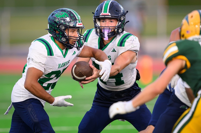 Saginaw Heritage senior running back Daijon Wynn takes a handoff from quarterback Anthony Fries during the first quarter of the Hawks’ eventual victory over Midland Dow.
