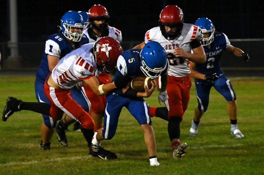 Ishpeming's Kian Gauthier (5) is able to find a hole before he gets tackled by North Central's Pryar LaBonte.
