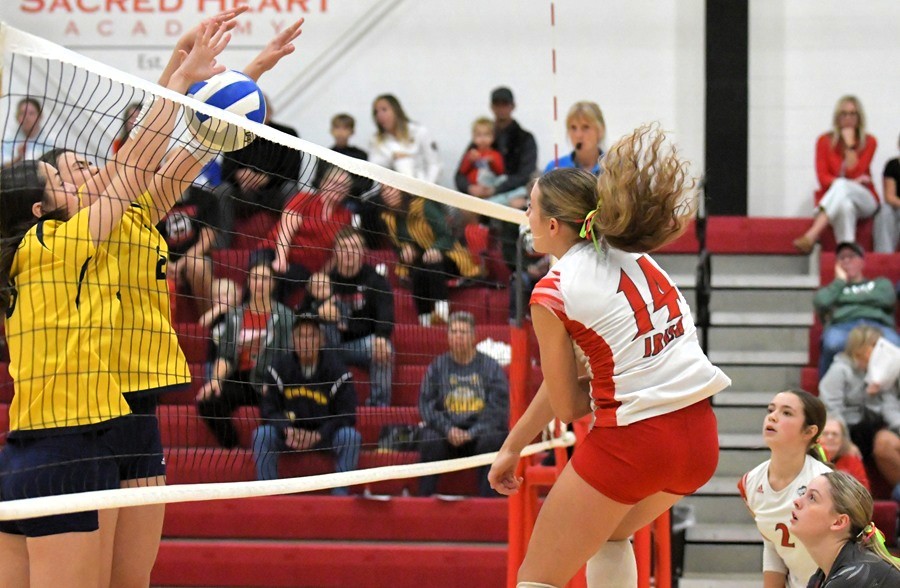Breckenridge and Mount Pleasant Sacred Heart blockers and hitters meet at the net.