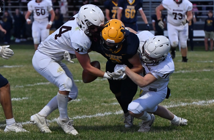 Menominee’s Kiefer Chouincard (11) gets a hand on the ball and dislodges it as he and Nathan Nelson (44) make a tackle against Negaunee.