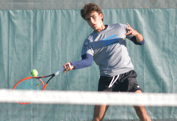 Lansing Catholic's Noah West returns a volley at No. 1 singles. 