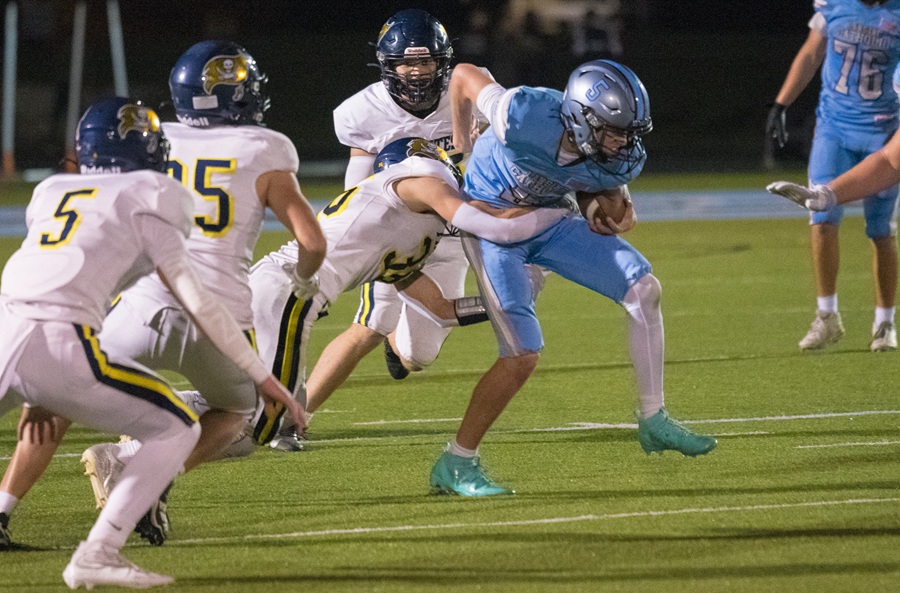 A Lansing Catholic ball carrier works to break away as Pewamo-Westphalia defenders swarm during a 35-13 victory.